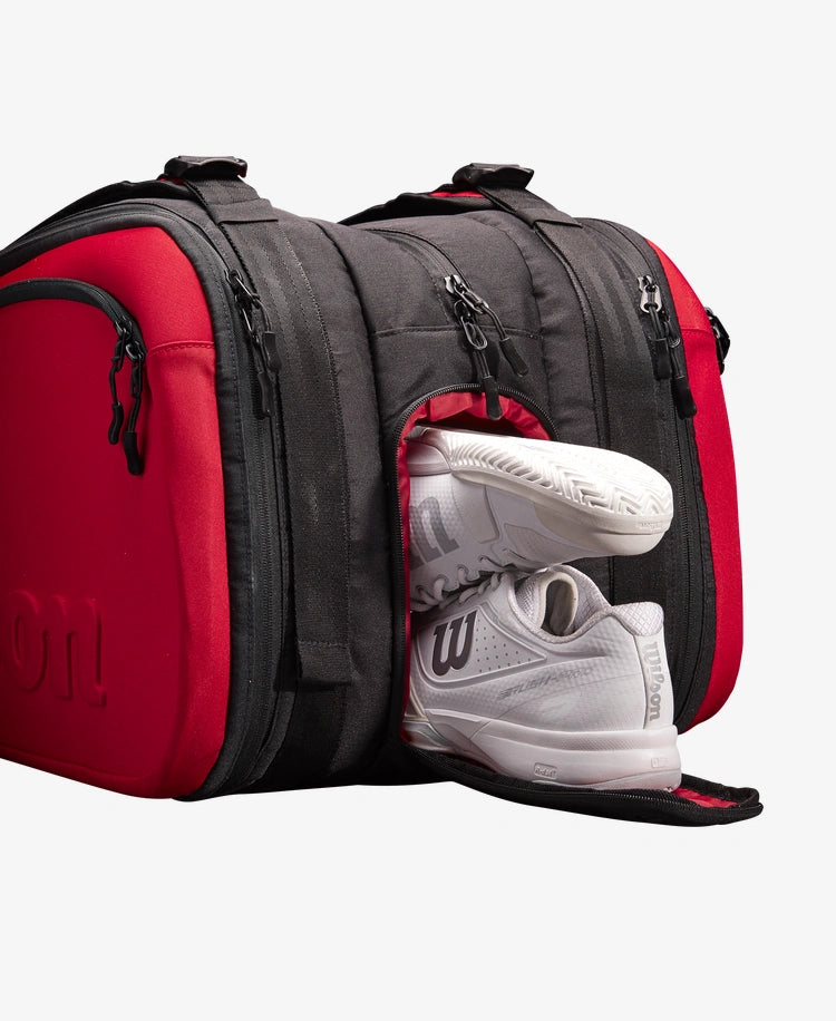 The Wilson Clash V2 Super Tour 15 Pack Racket Bag in black and red with shoes inside for display purposes which is available for sale at GSM Sports.