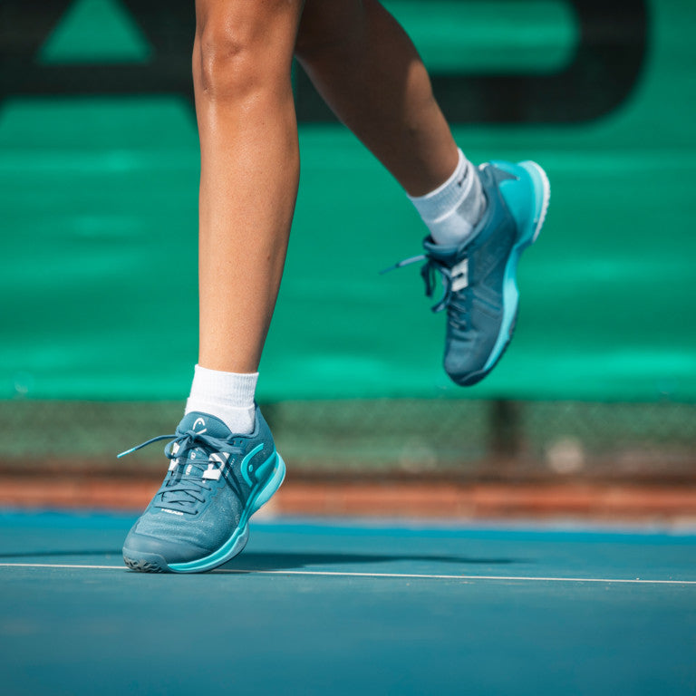 The Head Sprint Pro 3.5 Women's Tennis Shoes in blue on a tennis court available at GSM Sports