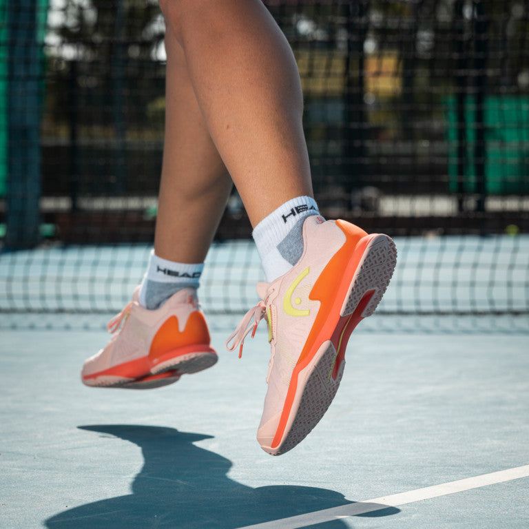 The Head Sprint Pro 3.5 Women's Tennis Shoes in pink on a tennis court available for sale at GSM Sports