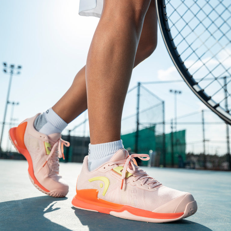 The Head Sprint Pro 3.5 Women's Tennis Shoes in pink on a tennis court available for sale at GSM Sports