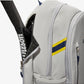 The Wilson US Open Tour Backpack in grey, blue and yellow with a tennis racket inside for display purposes which is available for sale at GSM Sports.